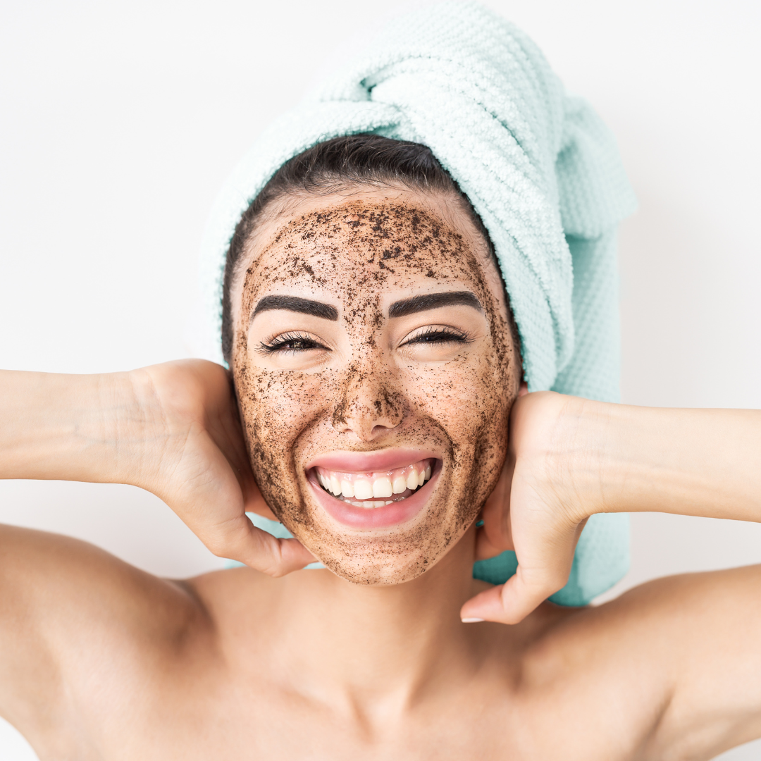 woman smiling and exfoliating her face