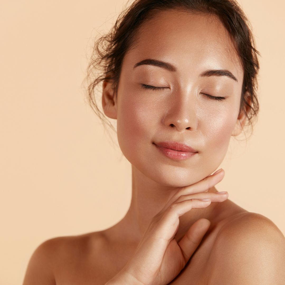 Woman smiling with hand against cheek and eyes closed