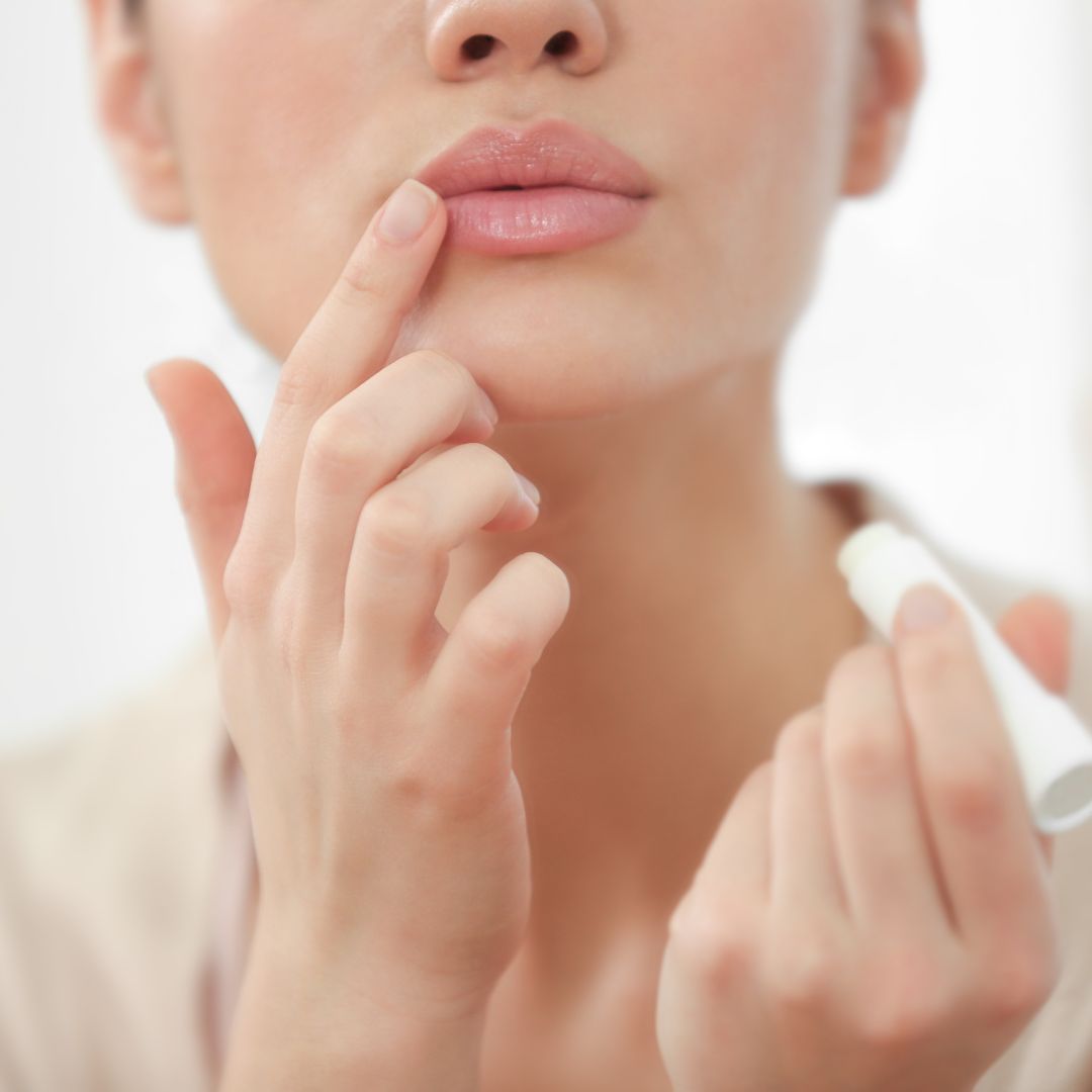 Woman applying lipstick to lips