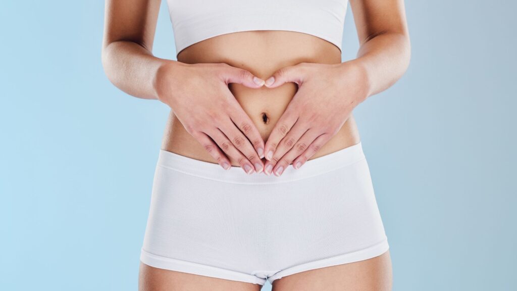 a woman making a heart over her stomach